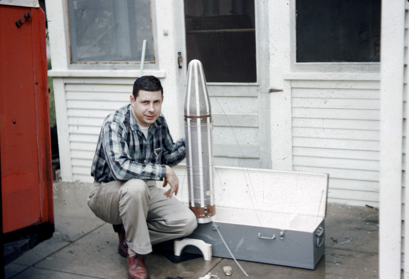 George Ludwig squating beside the Explorer 1 satellite before loading it into his car