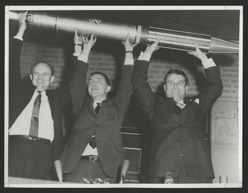 The Explorer 1 team, from left to right: William Pickering, James Van Allen, and Wernher von Braun, holding the replica triumphantly above their heads.