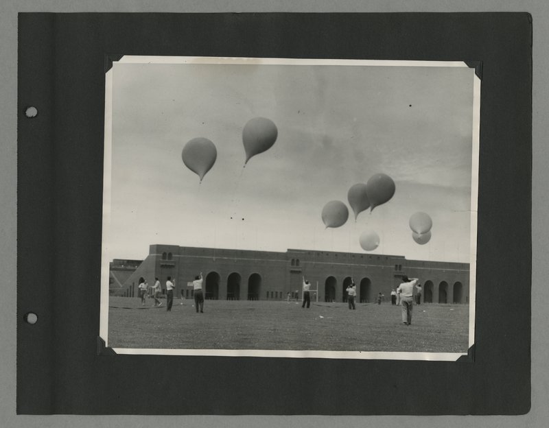 State University of Iowa students releasing weather ballons in front of Kinneck Stadium from Leslie Meredith's scrapbook, 1951-1955