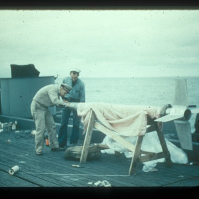 Two men inspecting the rackoon rocket before attaching it to the balloon