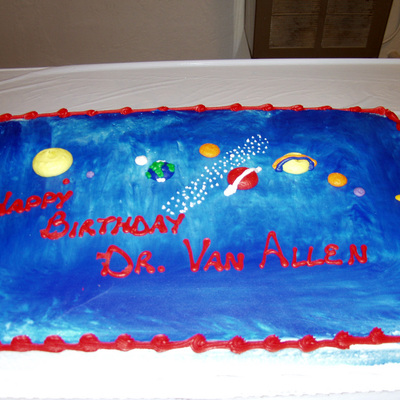 Van Allen Day cake with the solar system in icing and the words Happy Birthday Dr. Van Allen