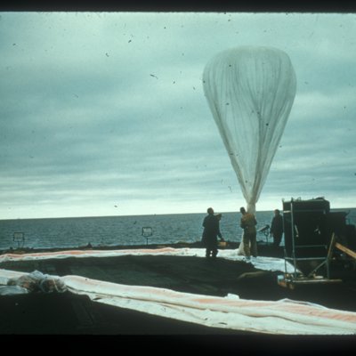 Photo of men wrangling a rackoon balloon on the ship platform