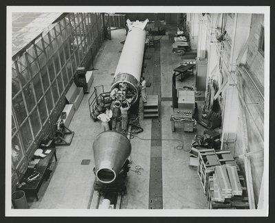 Several men attaching satellite system to the Vanguard rocket